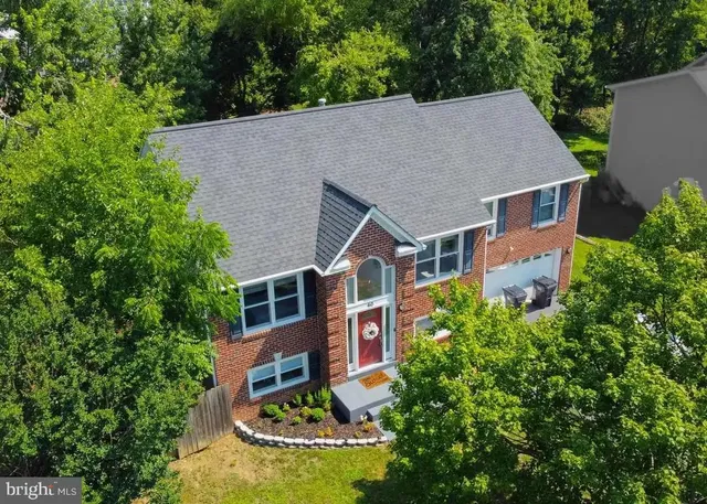 an aerial view of a house with yard and swimming pool