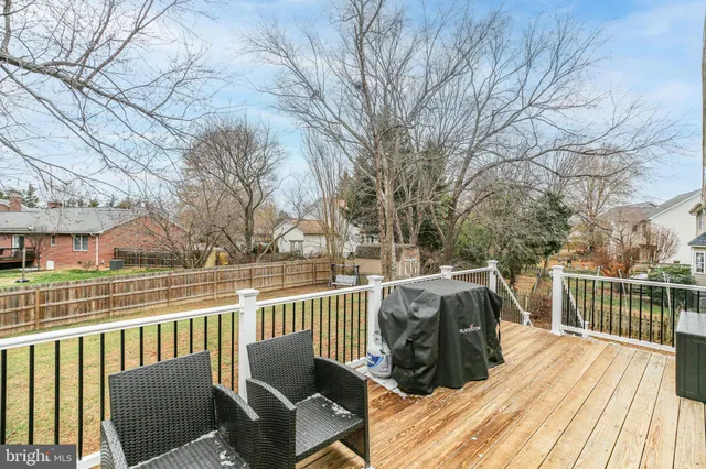 a view of a yard with trees and wooden fence