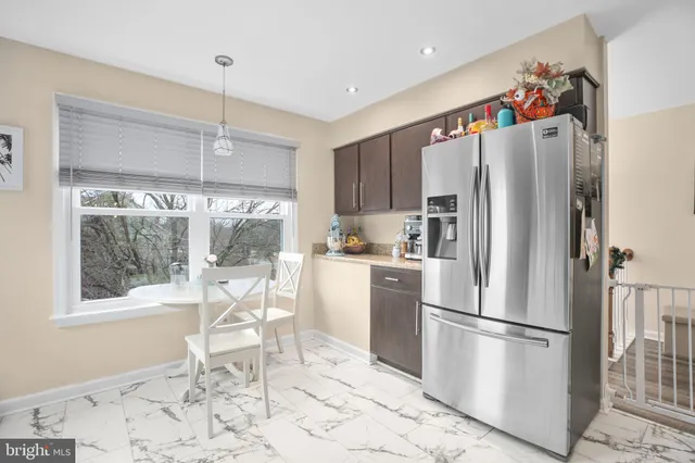 a kitchen with stainless steel appliances a refrigerator a table and chairs