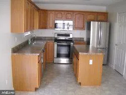 a kitchen with stainless steel appliances granite countertop a refrigerator a stove a sink and a microwave