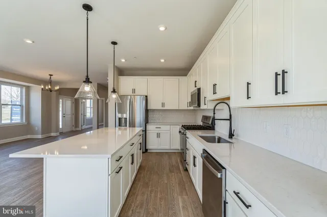 a kitchen with a sink a counter top space stainless steel appliances and a window