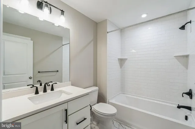 a bathroom with a sink toilet vanity and shower