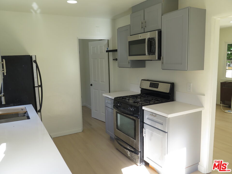 2128 20th Street, Unit B Santa Monica, CA 90405 - Photo 8 of 22 a kitchen with stainless steel appliances a stove microwave and refrigerator