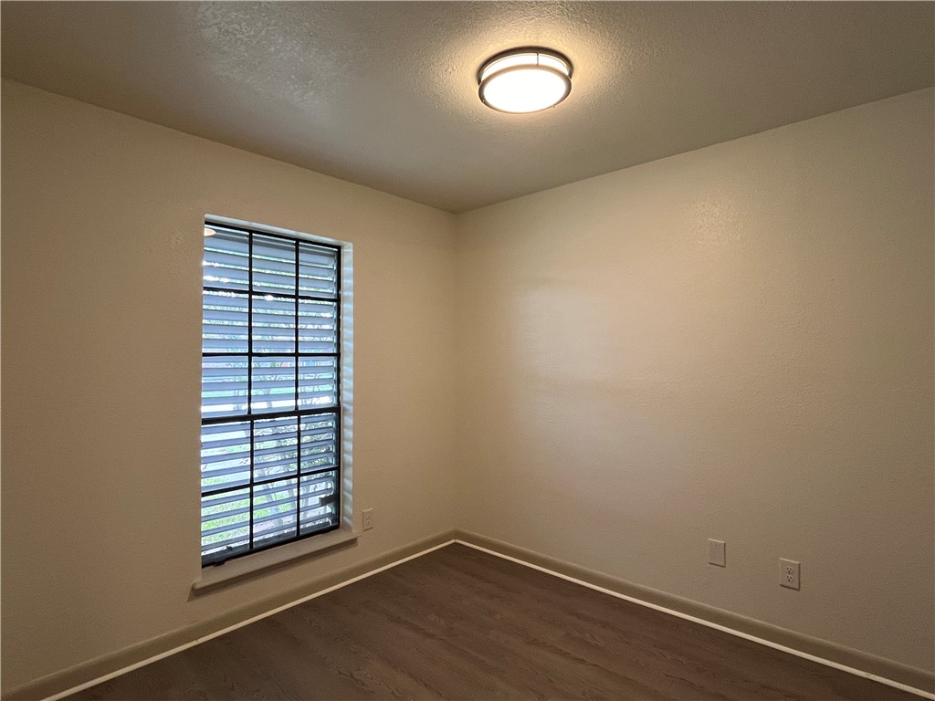 2930 River Crest Road Corpus Christi, TX 78415 - Photo 25 of 27 an empty room with wooden floor and windows