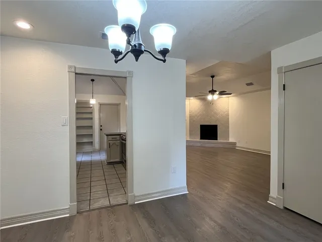 a view of a livingroom with a fireplace a chandelier and wooden floor