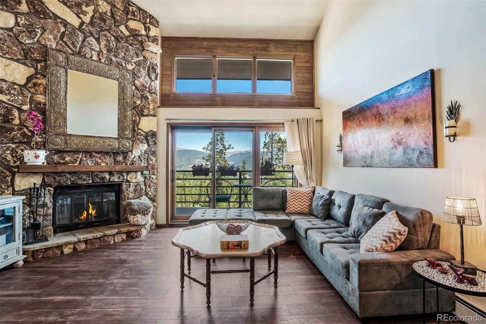 89310 Ryan Gulch Road, Unit 403 Silverthorne, CO 80498 - Photo 13 of 40 a living room with furniture a fireplace and a flat screen tv