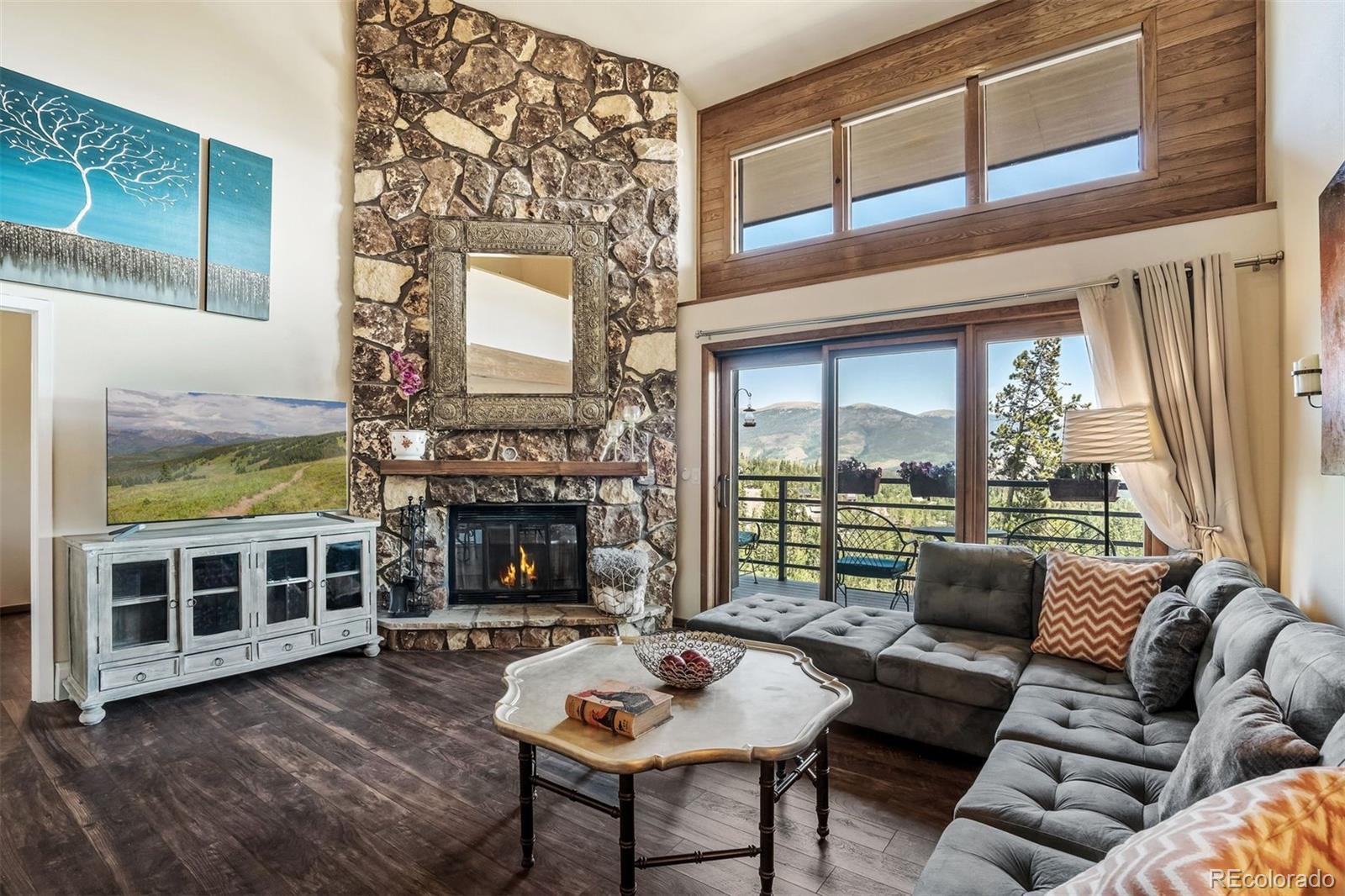 89310 Ryan Gulch Road, Unit 403 Silverthorne, CO 80498 - Photo 16 of 40 a living room with furniture a fireplace and a large window