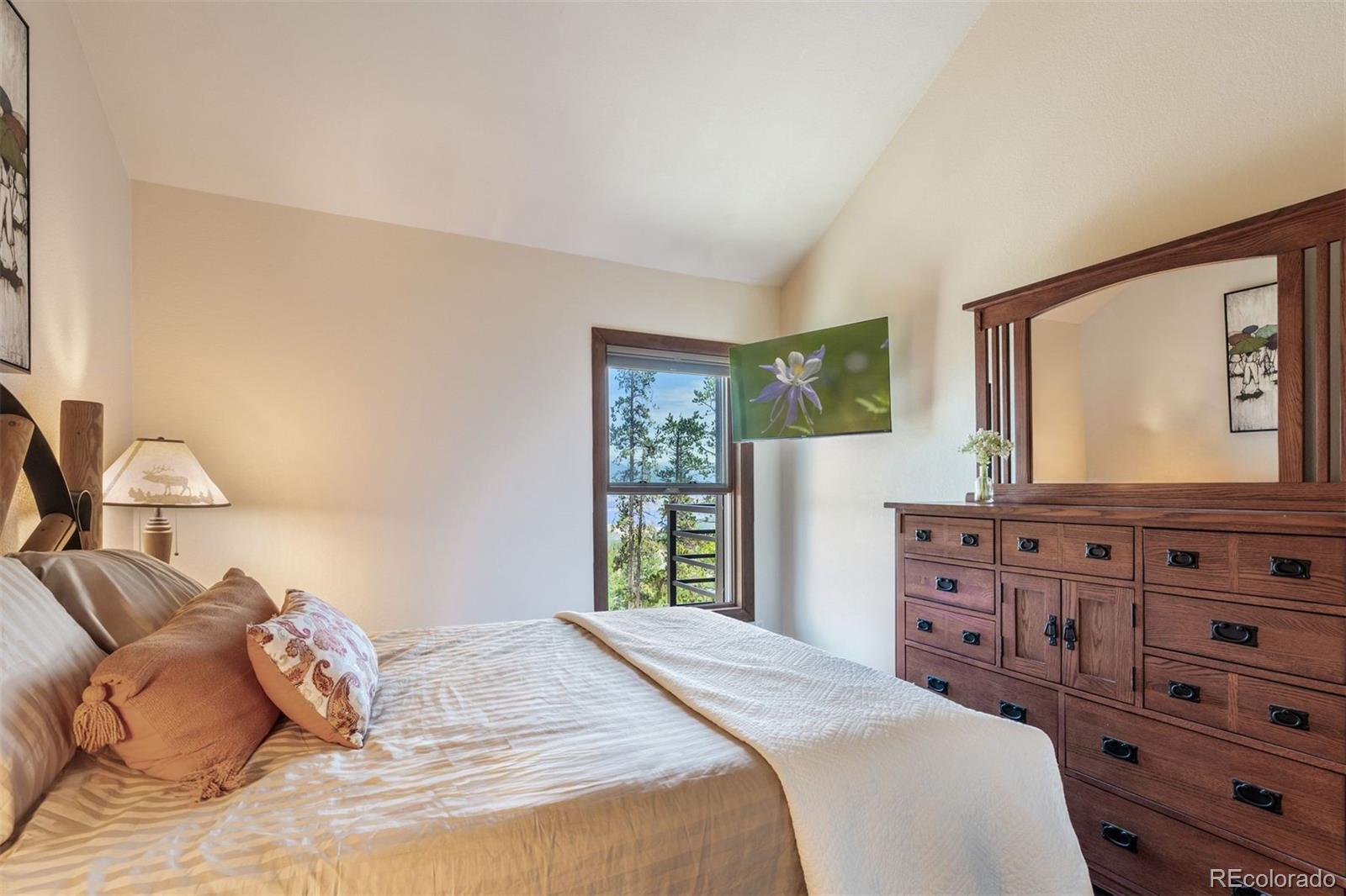 89310 Ryan Gulch Road, Unit 403 Silverthorne, CO 80498 - Photo 19 of 40 a bedroom with a bed and a dresser