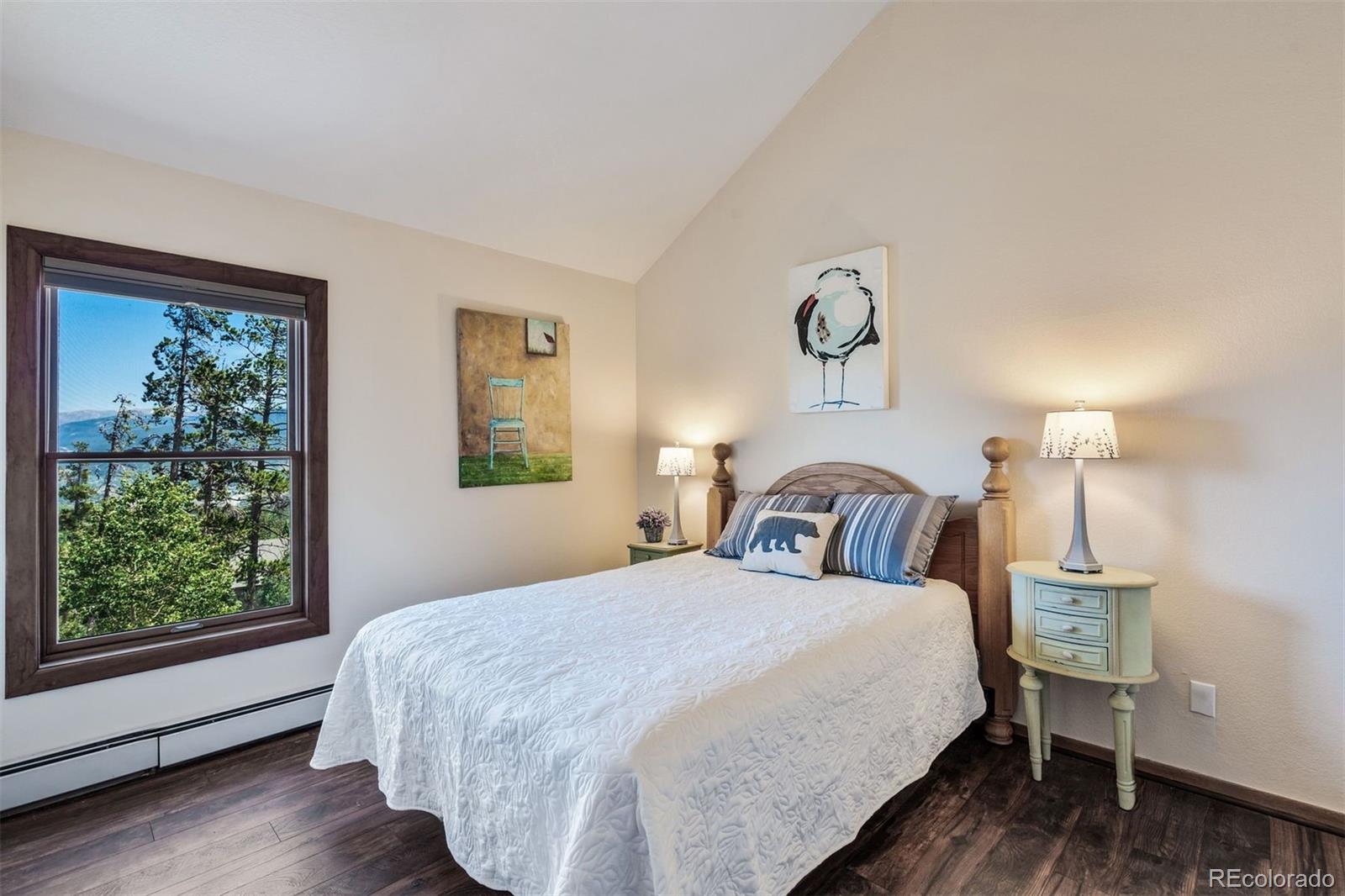 89310 Ryan Gulch Road, Unit 403 Silverthorne, CO 80498 - Photo 20 of 40 a bedroom with a bed and wooden floor