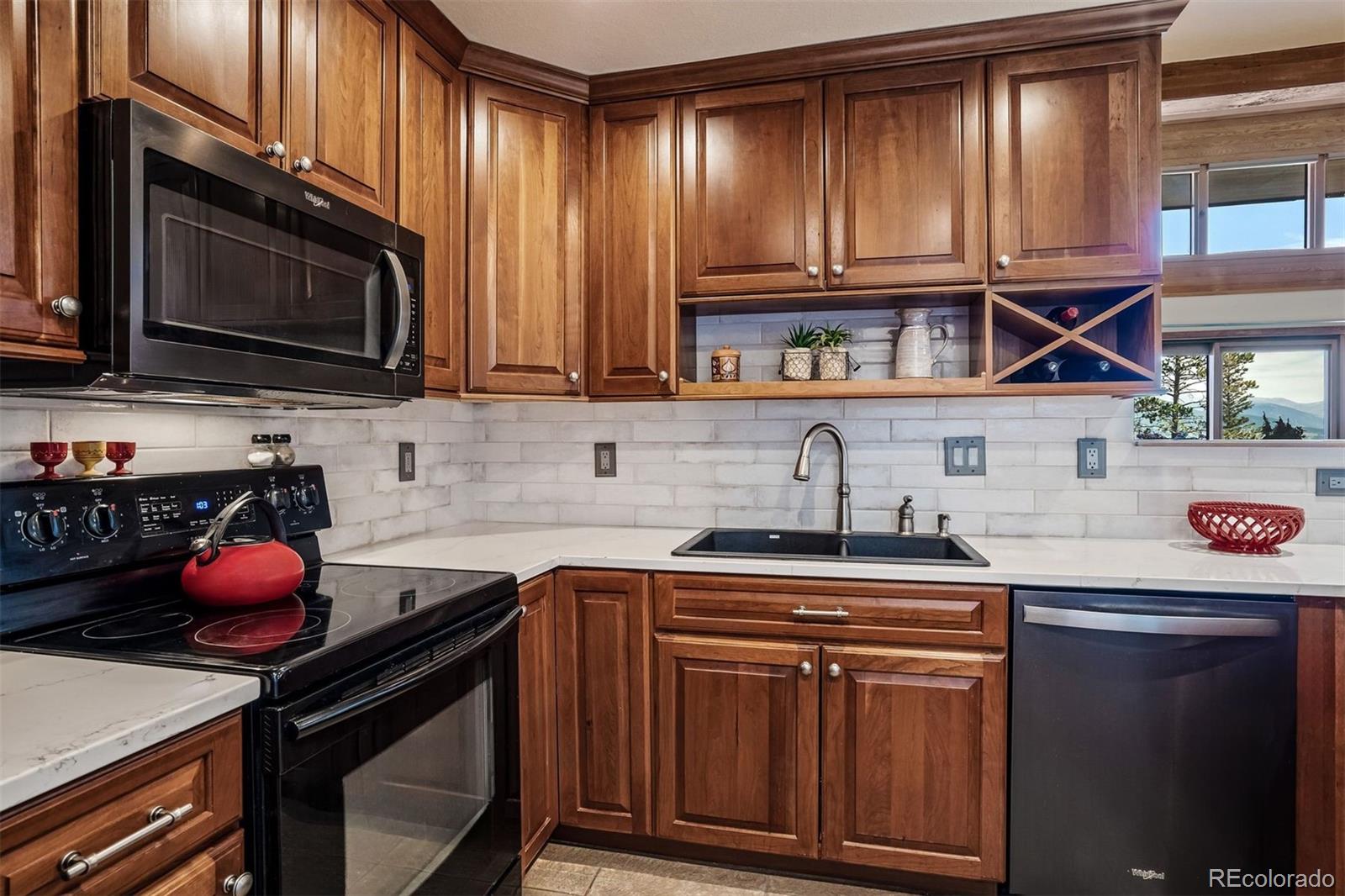 89310 Ryan Gulch Road, Unit 403 Silverthorne, CO 80498 - Photo 6 of 40 a kitchen with stainless steel appliances a stove a sink cabinets and a microwave