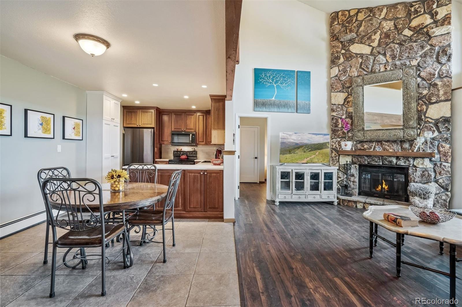 89310 Ryan Gulch Road, Unit 403 Silverthorne, CO 80498 - Photo 9 of 40 a dining room with furniture a fireplace and wooden floor