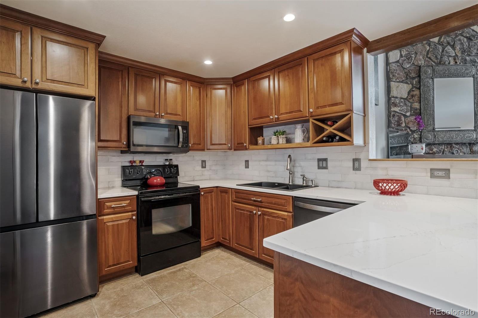 89310 Ryan Gulch Road, Unit 403 Silverthorne, CO 80498 - Photo 10 of 40 a kitchen with stainless steel appliances a refrigerator stove microwave and sink