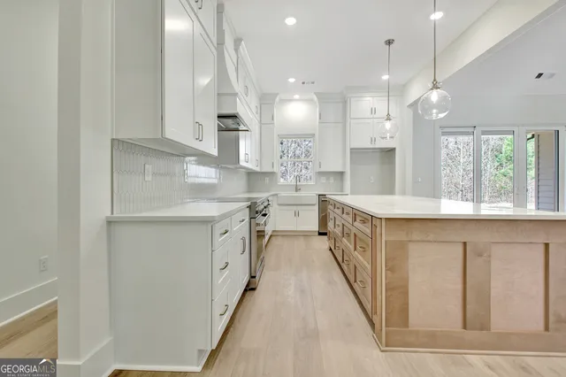 a view of a room with a large window and kitchen view