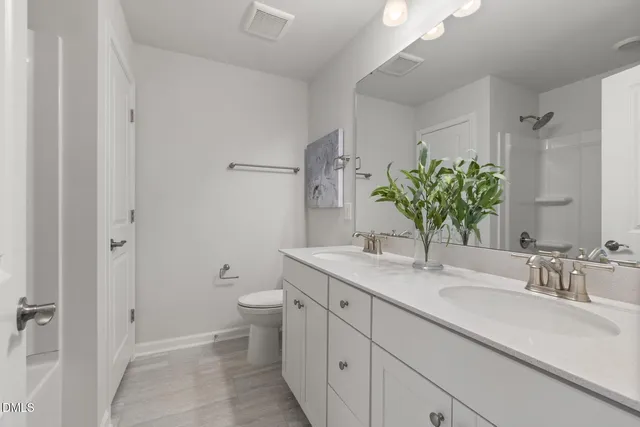 a bathroom with a granite countertop sink a toilet and a mirror