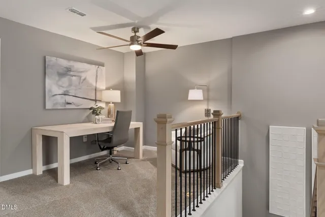 a view of a workspace with furniture and a window