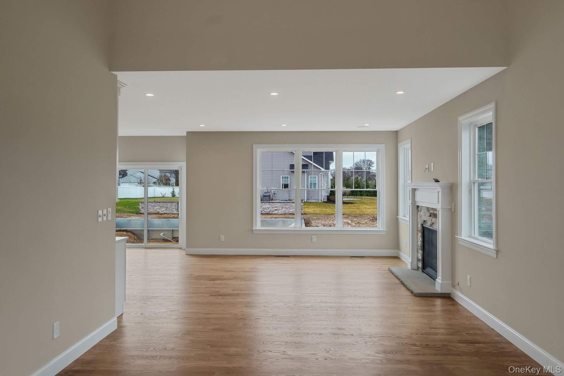 457 Pond Path East Setauket, NY 11733 - Photo 12 of 47 a view of an empty room with a window and wooden floor