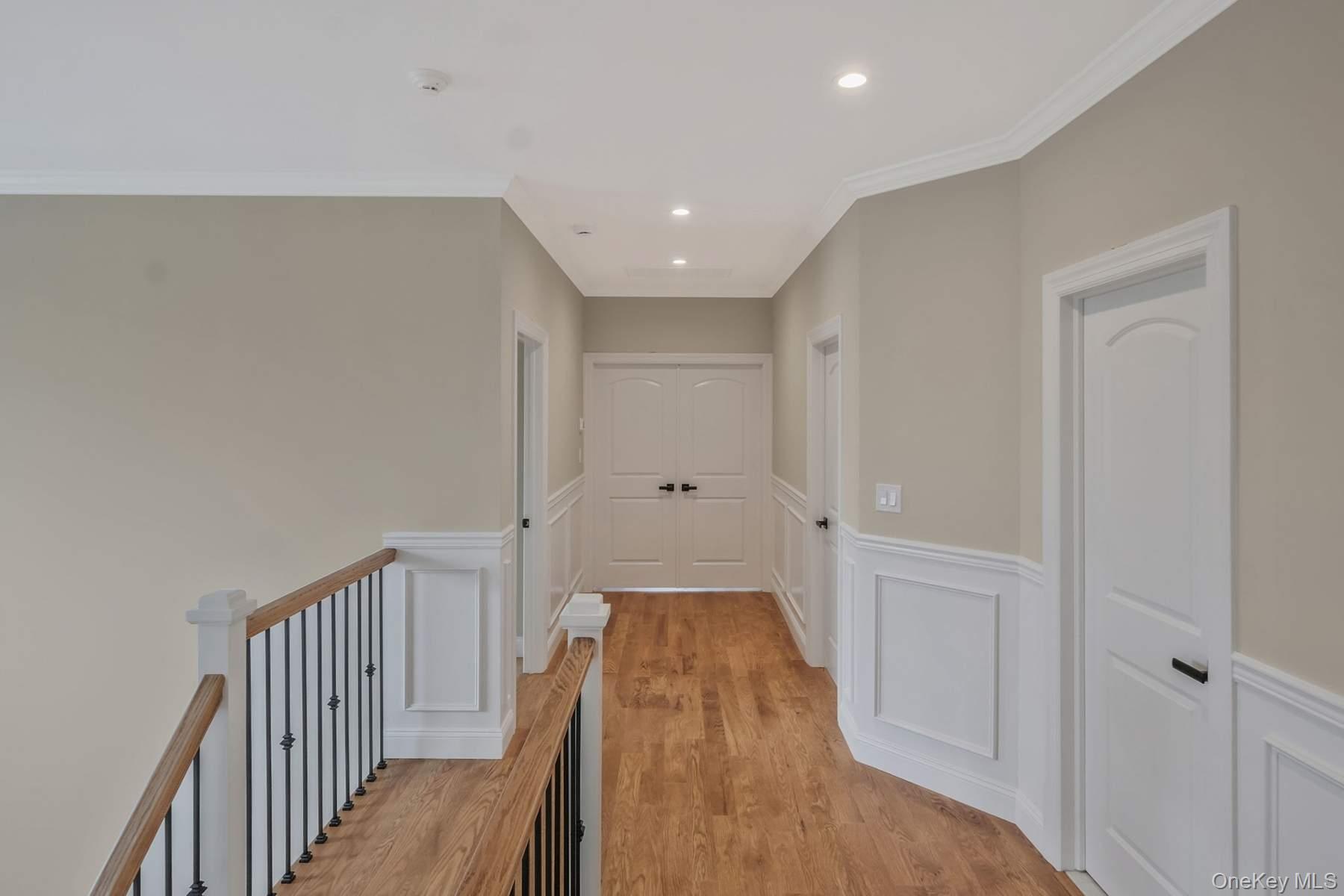 457 Pond Path East Setauket, NY 11733 - Photo 16 of 47 a view of a hallway with wooden floor and staircase