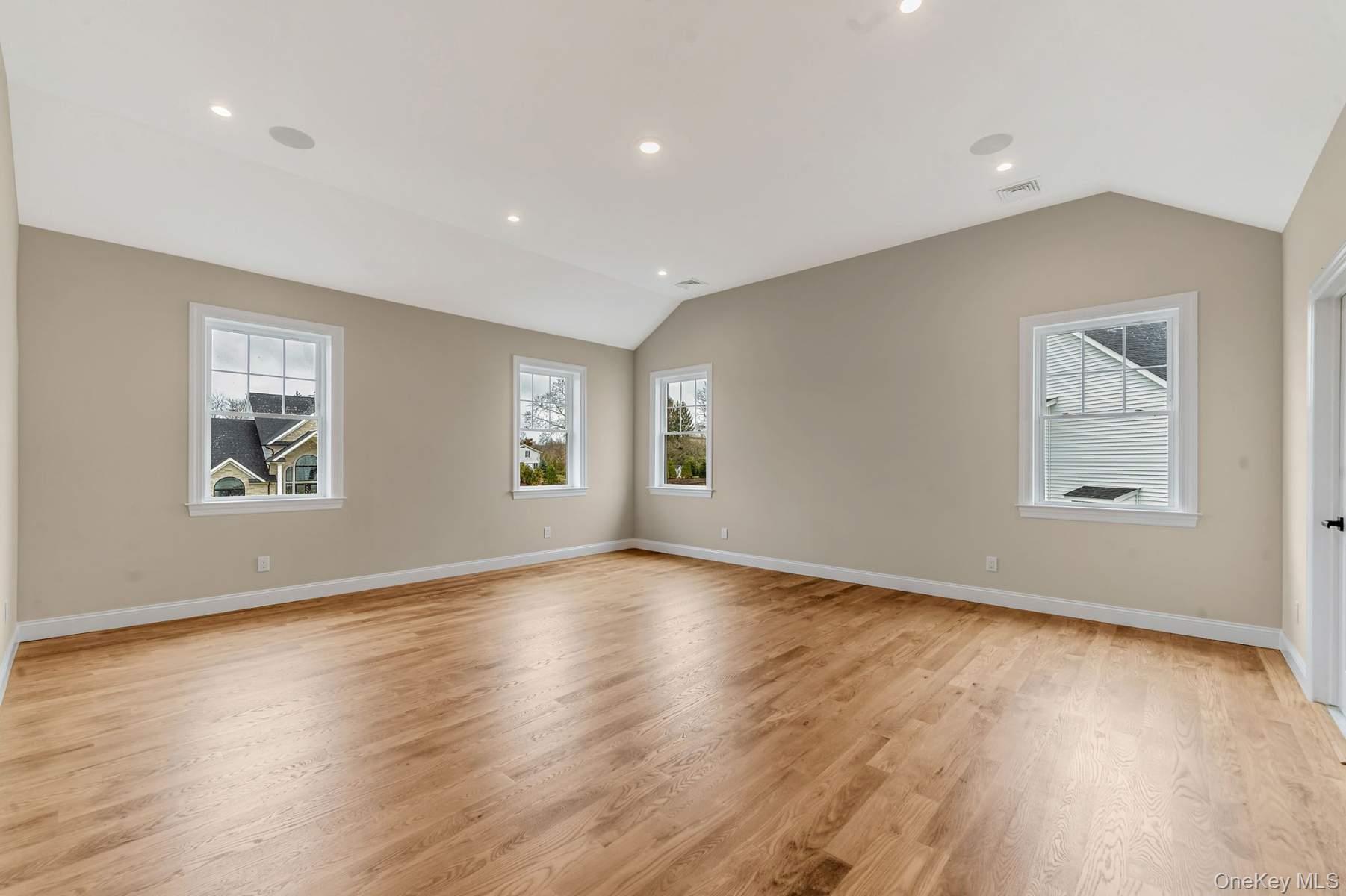 457 Pond Path East Setauket, NY 11733 - Photo 17 of 47 an empty room with wooden floor and windows
