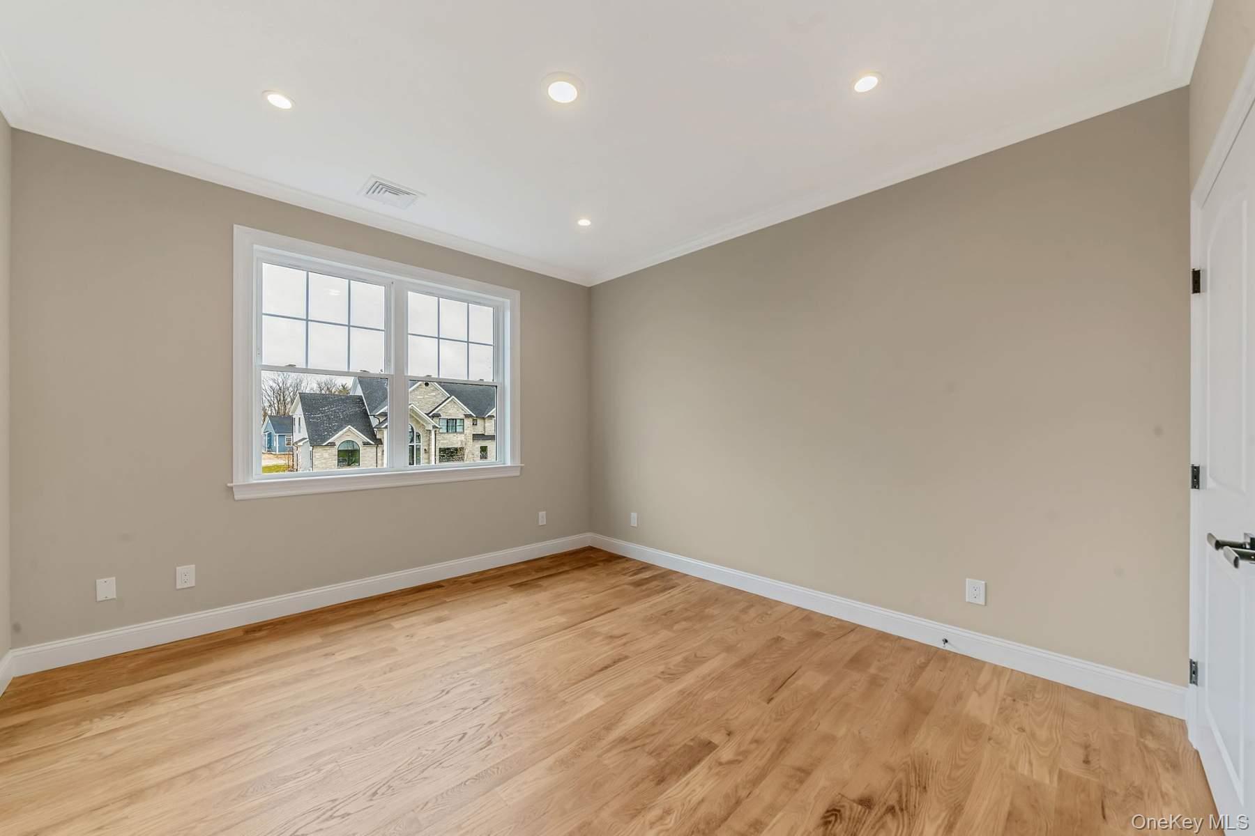 457 Pond Path East Setauket, NY 11733 - Photo 33 of 47 an empty room with window and wooden floor