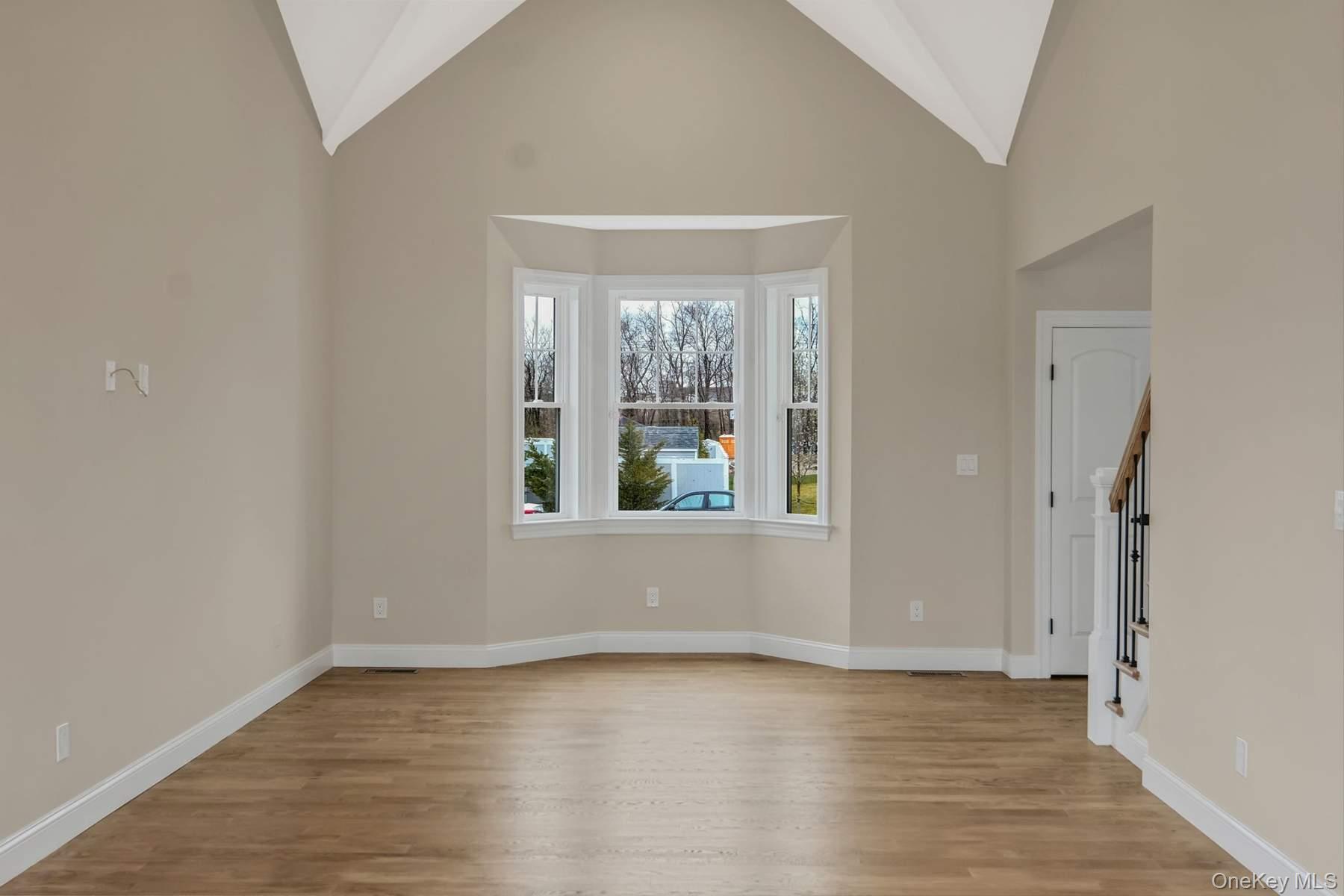 457 Pond Path East Setauket, NY 11733 - Photo 4 of 47 a view of an empty room with wooden floor and a window
