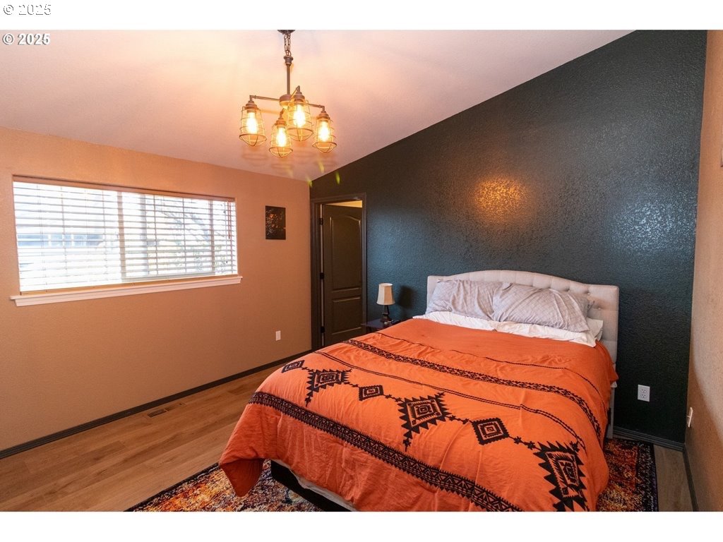 35 Wildwinds Street Florence, OR 97439 - Photo 13 of 32 a bedroom with a large bed and a chandelier