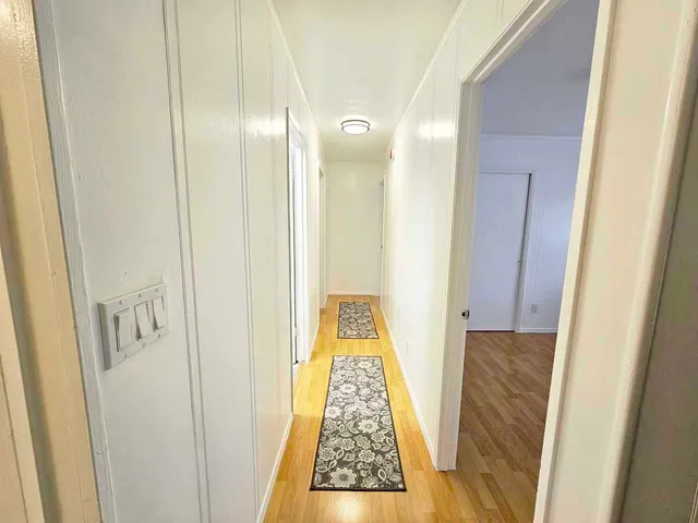 a view of hallway with wooden floor