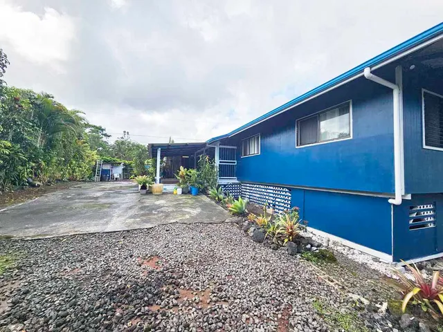 a backyard of a house with outdoor seating and trees