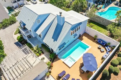 an aerial view of a house with outdoor space and seating area