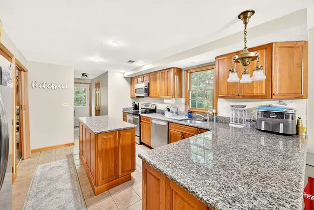 a kitchen with stainless steel appliances granite countertop sink stove and refrigerator