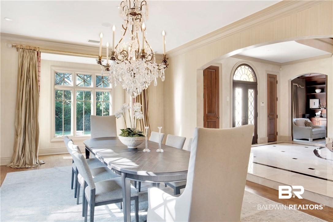 4 Chancery Court Mobile, AL 36608 - Photo 10 of 54 Dining area with light wood-type flooring, crown molding, and an inviting chandelier