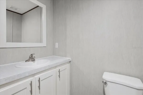 a bathroom with a sink a toilet and a mirror