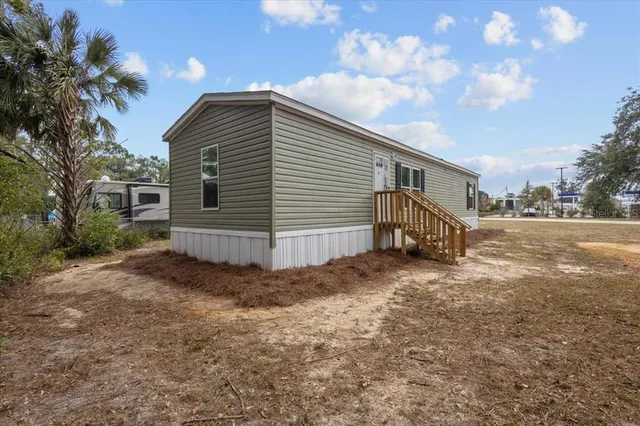 a view of a house with backyard and trees