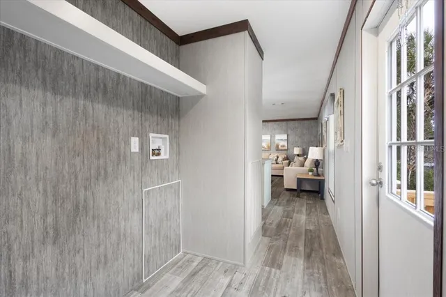 a view of a hallway with a livingroom with furniture and wooden floor
