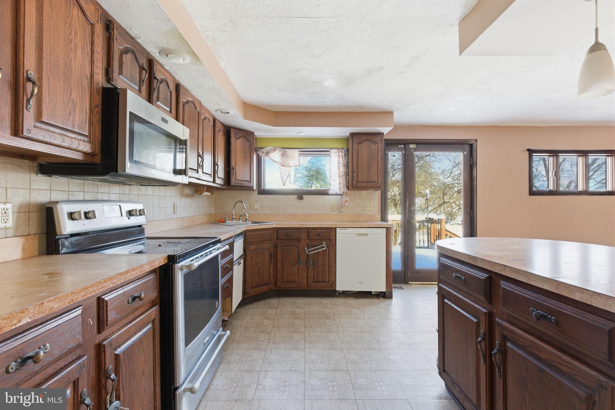 1057 Bridge Road Bensalem, PA 19020 - Photo 11 of 37 a kitchen with stainless steel appliances granite countertop a stove a sink and a microwave