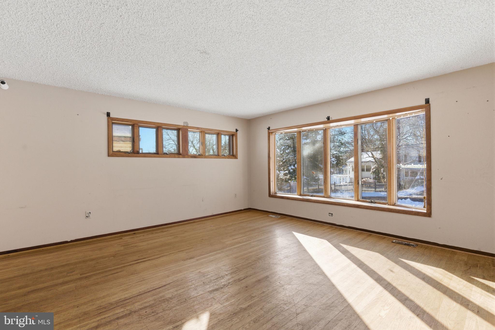 1057 Bridge Road Bensalem, PA 19020 - Photo 6 of 37 a view of an empty room with a window and wooden floor