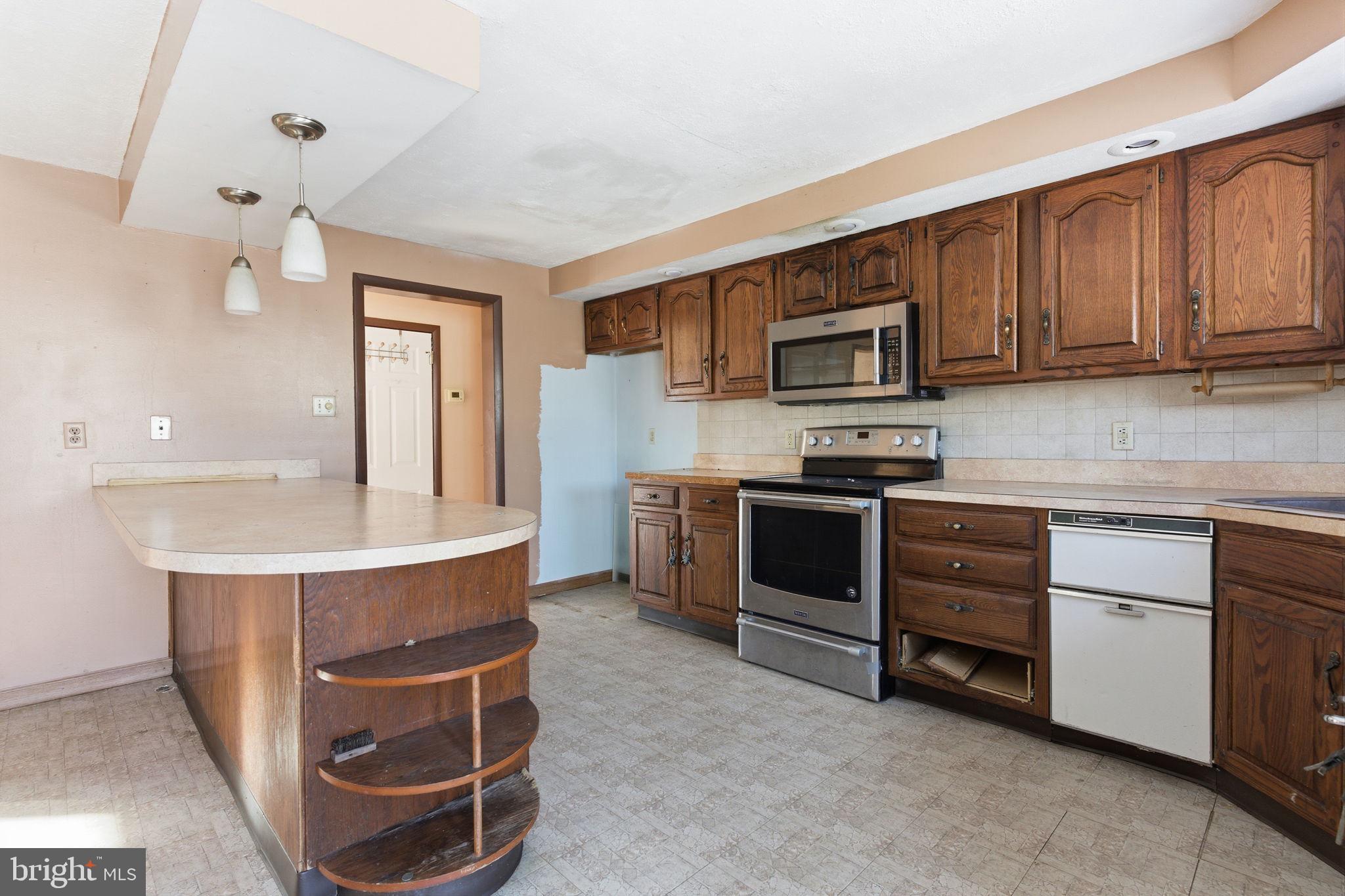 1057 Bridge Road Bensalem, PA 19020 - Photo 9 of 37 a kitchen with stainless steel appliances kitchen island granite countertop a stove top oven a sink dishwasher and cabinets with wooden floor