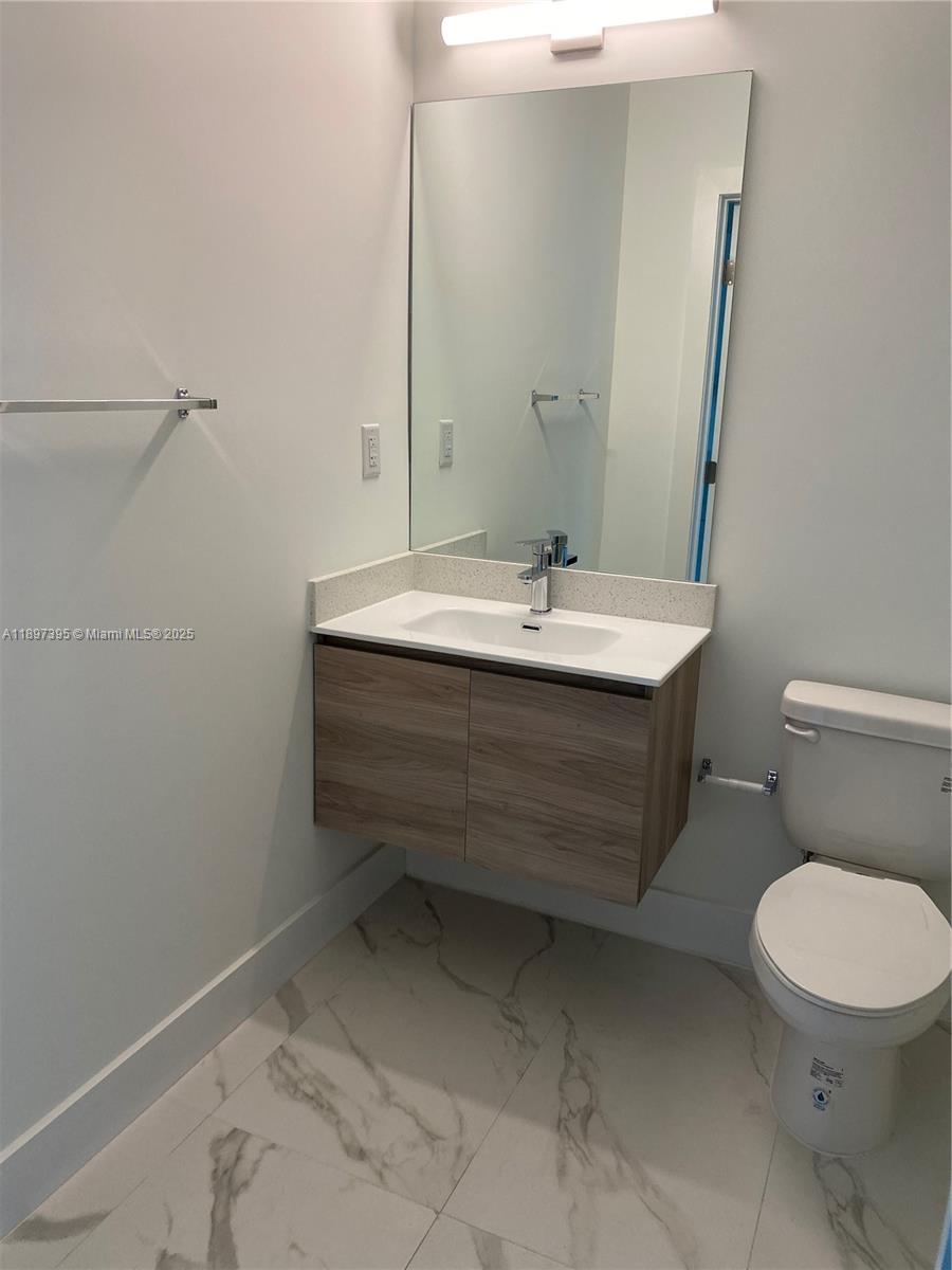 4100 Southwest 64th Avenue, Unit 314 Davie, FL 33314 - Photo 6 of 17 a bathroom with a sink toilet and mirror