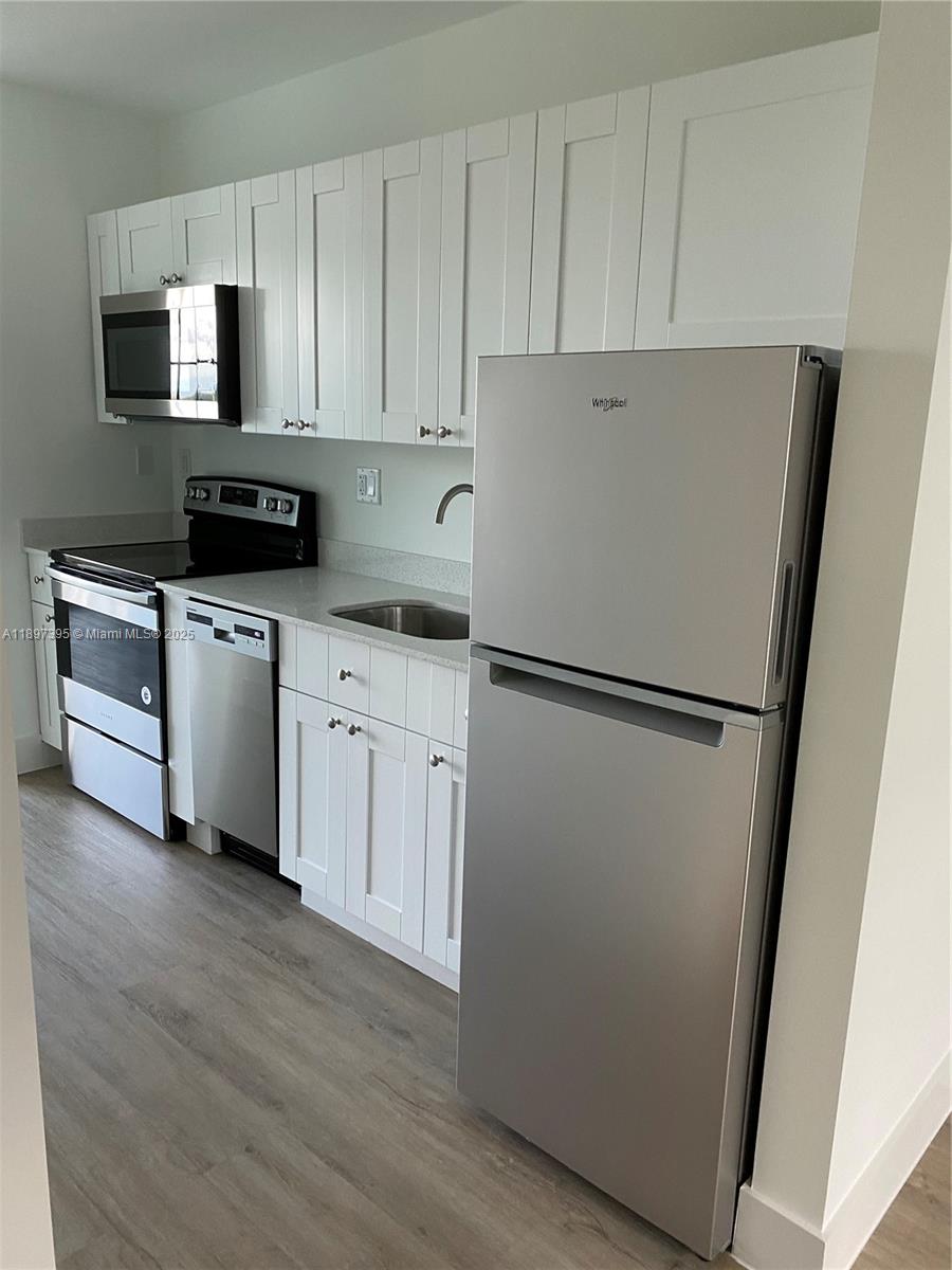 4100 Southwest 64th Avenue, Unit 314 Davie, FL 33314 - Photo 10 of 17 a kitchen with a refrigerator a stove top oven a sink and dishwasher