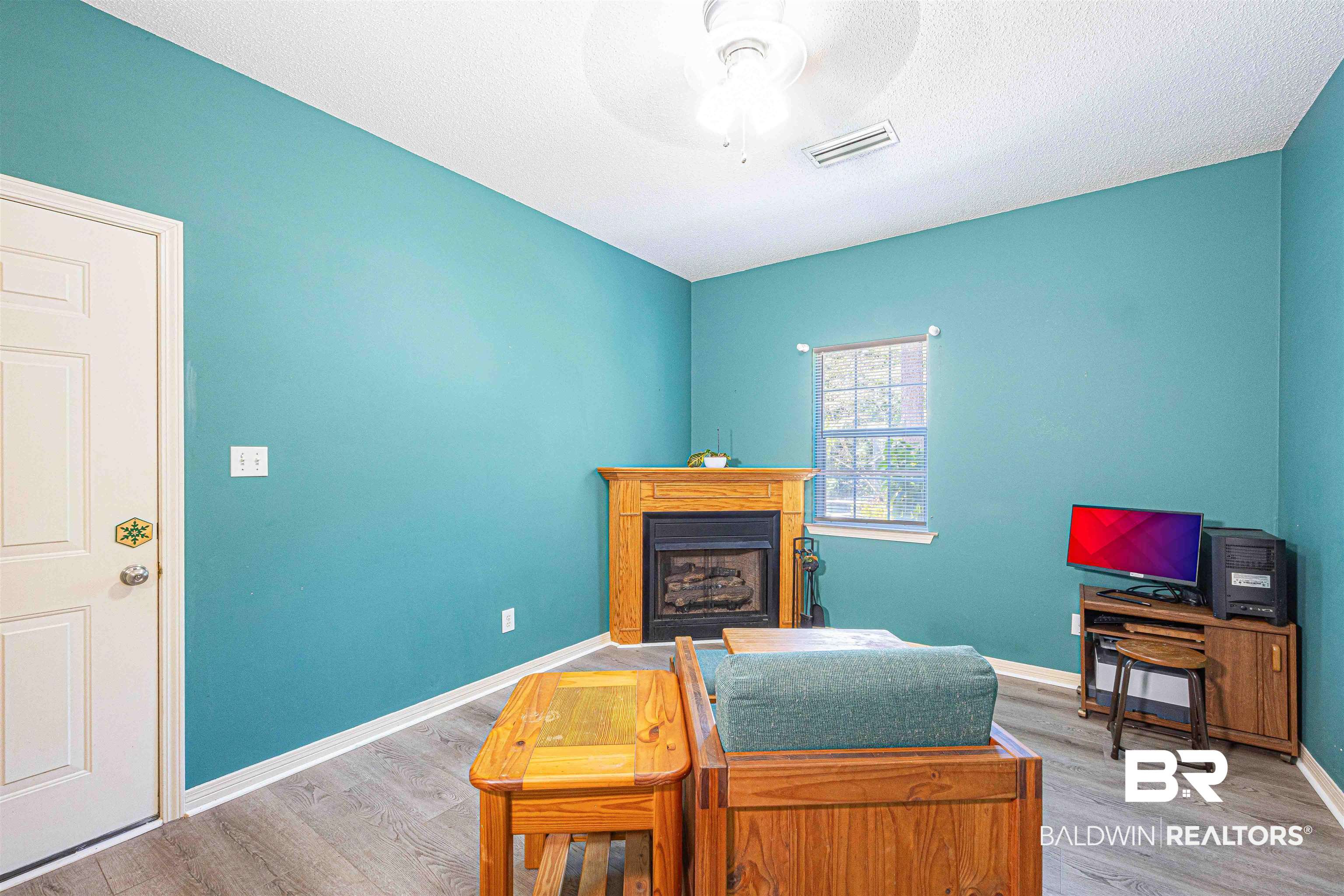 175 Montclair Loop Daphne, AL 36526 - Photo 27 of 44 Living area featuring light wood-style floors, a fireplace, ceiling fan, and a textured ceiling