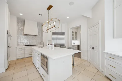 a kitchen that has a lot of cabinets in it and wooden floors