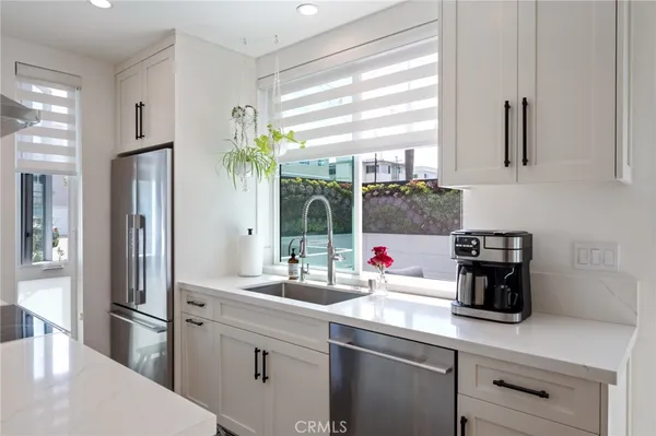 a kitchen with stainless steel appliances a sink stove and refrigerator