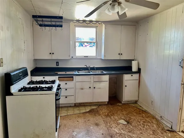 a kitchen with granite countertop a stove sink and cabinets