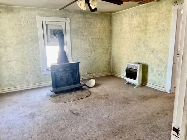a view of an empty room with a fireplace and a window