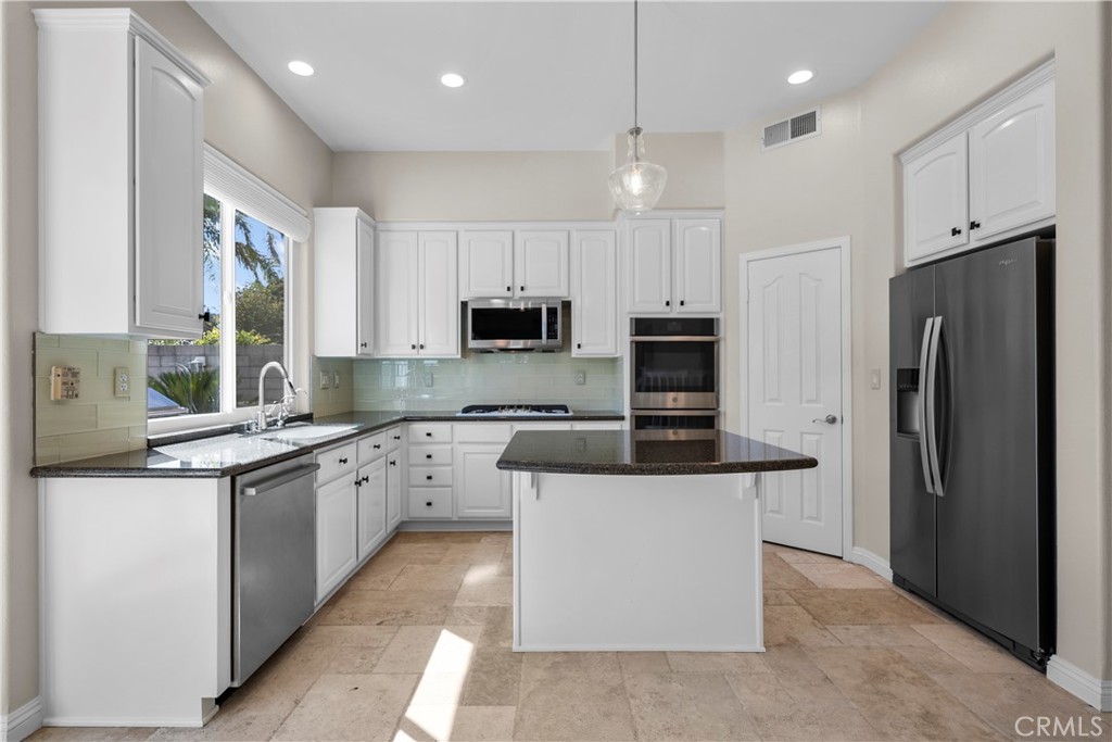 25512 Wilde Avenue Stevenson Ranch, CA 91381 - Photo 19 of 53 a kitchen with stainless steel appliances granite countertop a refrigerator a stove top oven a sink and dishwasher