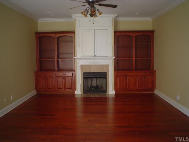 7321 Newport Avenue Raleigh, NC 27613 - Photo 4 of 5 an empty room with wooden floor a fireplace and window