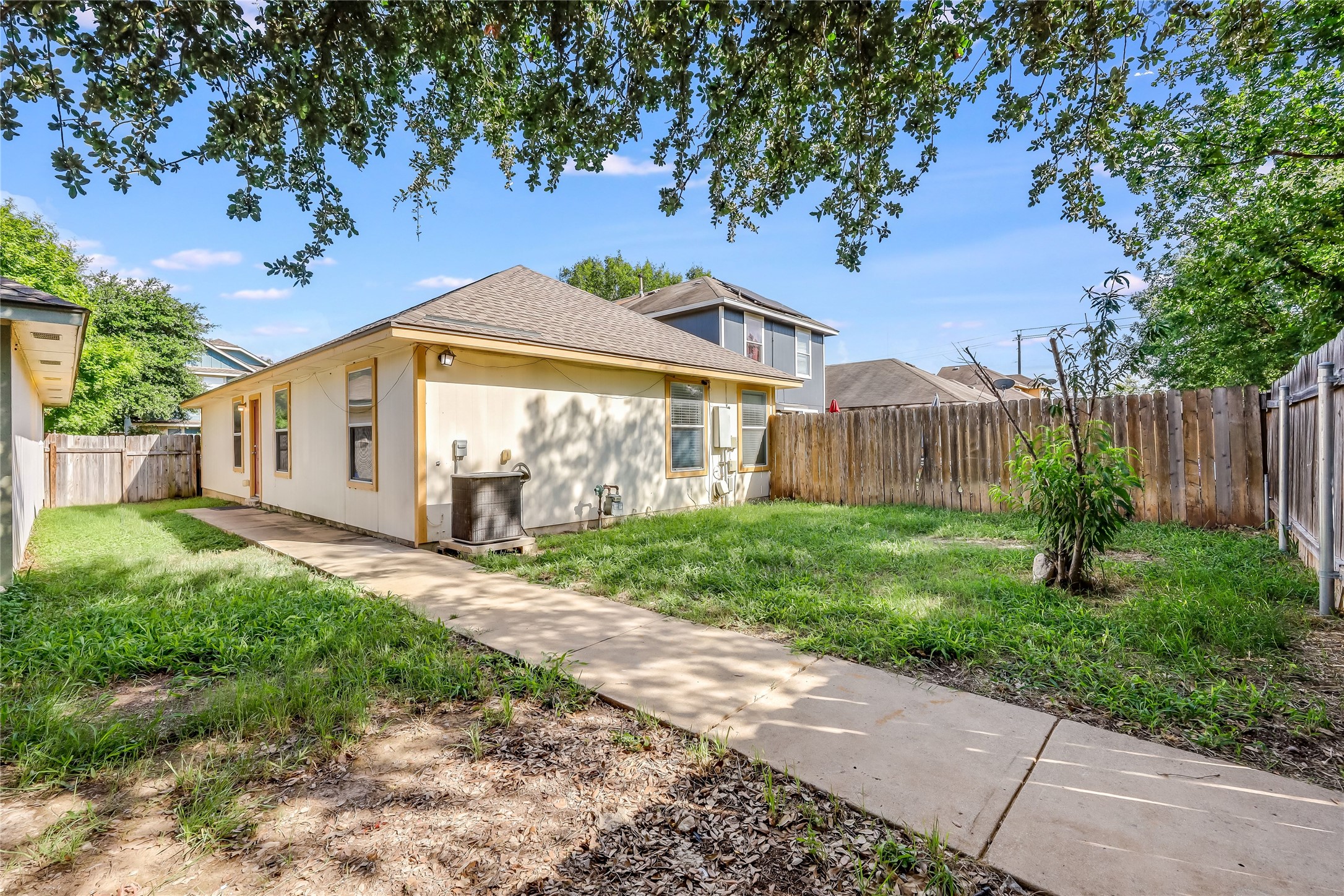 4510 Secure Lane Austin, TX 78725 - Photo 24 of 24 a view of a white house next to a yard with big trees