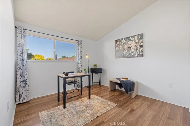 a view of a workspace with furniture and wooden floor