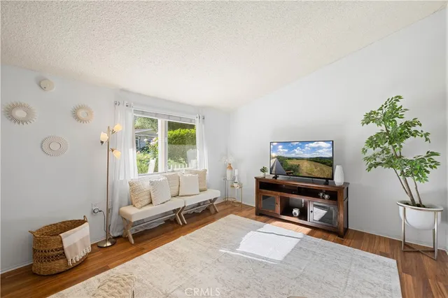 a living room with furniture a window and a flat screen tv