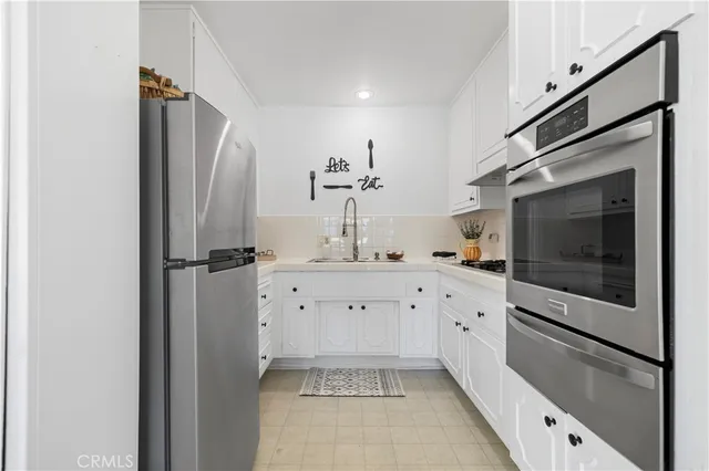 a kitchen with stainless steel appliances a refrigerator sink and cabinets