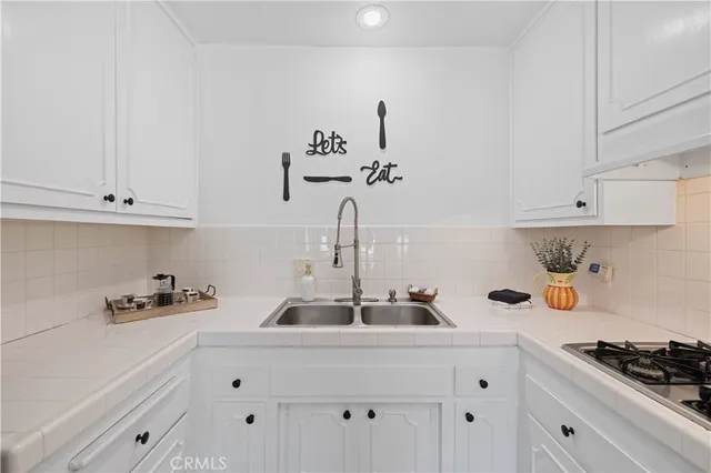 a kitchen with white cabinets and stove